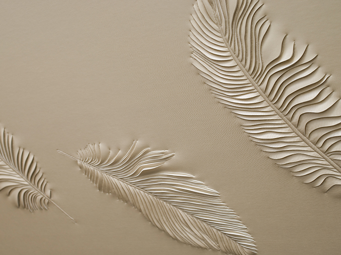 Detail of hand-sculpted artwork by Helen Amy Murray with feathers in cream faux leather