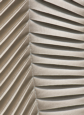 Detail of hand-sculpted artwork with herringbone design in taupe faux suede with taupe colour silk crepe satin