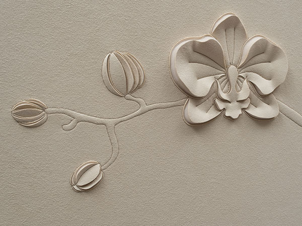 Close up detail of a hand-sculpted orchid flower and buds in off-white faux suede